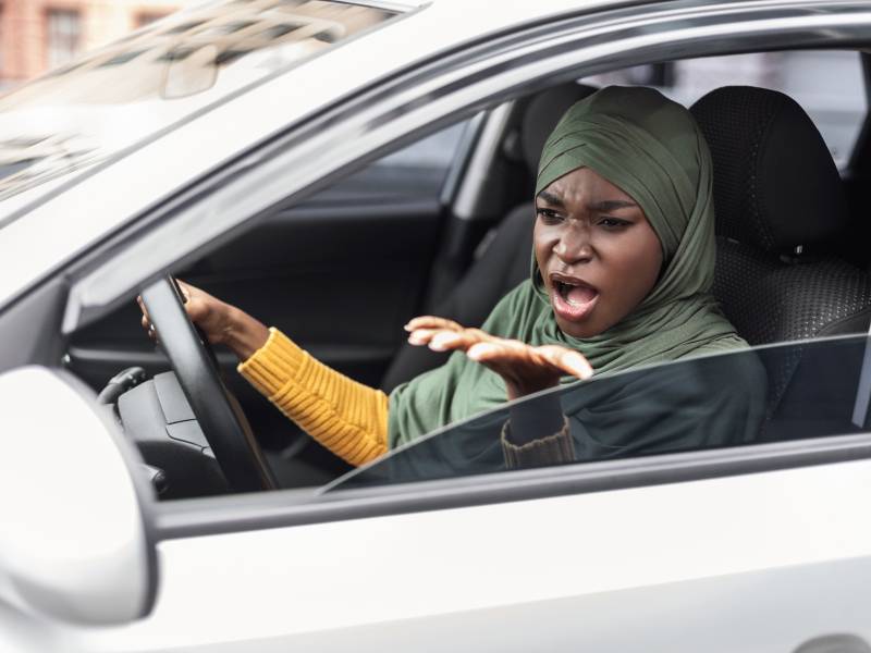 black woman driving car while arguing